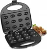An open electric waffle maker with a plate of finished nut-shaped pastries next to it. Anteprima dell’immagine prodotto