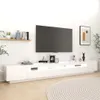 A white TV stand with a large TV mounted above it, decorated with various items. Náhled obrázku produktu