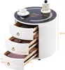 A white, cylindrical nightstand with three drawers, a black glass top with wireless charging capabilities, and a decorative item on top. Voir les images du produit