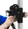 A close-up shot of a person's hands adjusting a black pulley system attached to a white pole. Produktbild-Vorschau