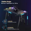 A gaming desk with LED lights and weights on top, showcasing its stability and load capacity. Produktbild-Vorschau
