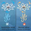 A split image showing a ceiling fan in two modes: 'Natürlicher Wind' (natural wind, cool in summer) on the left and 'Warmer Wind' (warmer wind, warm in winter) on the right. Each side illustrates the airflow direction and associated weather icons (snowflak Produktbild-Vorschau