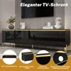 A black TV cabinet with gold accents and metal legs, displayed in a modern living room setting with decorative items and a TV on the wall. Anteprima dell’immagine prodotto