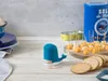 A blue whale-shaped toothpick dispenser sits on a wooden table next to crackers and cheese cubes. Náhled obrázku produktu