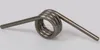 A metal spring on a light gray background. Produktbild-Vorschau