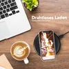 A desk scene with a laptop, coffee, and a smartphone charging wirelessly. Produktbild-Vorschau