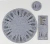 A set of Christmas-themed placemats and a coaster made of gray felt with black tree designs, arranged on a light gray background. Produktbild-Vorschau