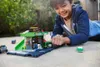 A young boy plays with a toy bus station and cars outdoors. Náhľad obrázku produktu