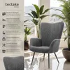 A gray armchair is shown next to large potted plants in a well-lit room with a window in the background. Produktbild-Vorschau
