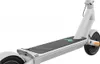 A close-up, low-angle view of the deck and rear wheel of a white electric scooter against a white background. Voir les images du produit