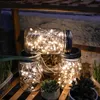 Mason jar solar lights on a wooden shelf with plants. Produktbild-Vorschau