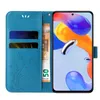 A blue flip cover phone case with floral and butterfly embossing, showing card slots and a banknote inside, next to a smartphone displaying a colorful abstract wallpaper. Produktbild-Vorschau