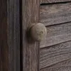 A close-up of a wooden cabinet door with a round wooden knob. Náhľad obrázku produktu