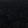 A close-up view of a black shaggy carpet. Produktbild-Vorschau