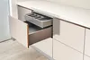 A close-up view of kitchen drawers, one of which is open to reveal an organizer tray. Podgląd zdjęcia produktu
