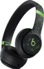A close-up, angled view of a pair of black Beats By Dre Solo 4 headphones with a Minecraft-themed green pixelated design. Produktbild-Vorschau
