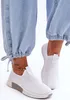 Close-up of a person's feet wearing white slip-on sneakers and light blue jeans. Produktbild-Vorschau