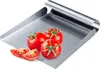 A stainless steel vegetable scoop with tomatoes on it. Produktbild-Vorschau