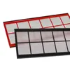 Two filters are arranged diagonally on a white background. One filter is in the foreground with a black frame, and the other is behind it with a red frame. The filters have a grid-like structure with white, pleated material within the grid. Produktbild-Vorschau