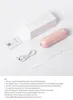 An arrangement of a pink portable fan, its box, charging cable, strap, and manual on a white surface. Anteprima dell’immagine prodotto