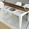 A dining table with its top open, revealing storage compartments. The table is set in a dining area with chairs in the background. Anteprima dell’immagine prodotto