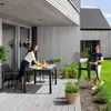 A couple is setting up a patio dining set on a wooden deck. Náhled obrázku produktu