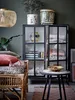 A cozy living room scene with a rattan daybed, a glass cabinet, and decorative items. Produktbild-Vorschau