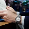 A man wearing a suit and watch is reading a newspaper. Náhľad obrázku produktu