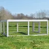 An outdoor enclosure for small animals, such as rabbits or chickens, sits on a grassy lawn under a clear blue sky. Produktbild-Vorschau