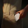 A person is putting a white power bank into their pocket. Produktbild-Vorschau