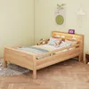 A child's bed with a teddy bear and pillows, set in a bedroom. Voir les images du produit