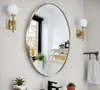 A modern bathroom setting with an oval mirror, wall sconces, a faucet, and a towel rack. Podgląd zdjęcia produktu