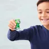 A young boy is holding a small green toy dog figure in his hand, smiling at the camera. Anteprima dell’immagine prodotto