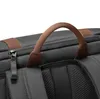 A close-up view of the top handle and zipper of a black backpack. Produktbild-Vorschau
