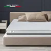 A mattress on a bed frame with pillows in a bedroom setting. Produktbild-Vorschau