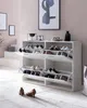 A hallway or entryway scene featuring a white shoe cabinet with multiple open compartments displaying various shoes, with artwork on the wall and a rug on the floor. Náhled obrázku produktu