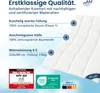 A close-up of a white quilted blanket with descriptive text and certification logos overlaid. Voir les images du produit