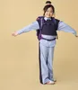 A young girl wearing a backpack and school uniform stands with her arms outstretched against a plain background. Produktbild-Vorschau