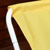 A close-up view of the yellow fabric of a lounge chair, attached to a white metal frame. The background is a wooden surface. Voir les images du produit