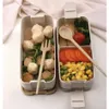 A bento box lunch with food items and cutlery. Podgląd zdjęcia produktu