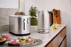 A toaster and kettle on a kitchen counter with toast and avocado toast in the foreground. Anteprima dell’immagine prodotto