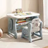 A child's desk and chair set is shown in a room with a textured wall and a rug. Produktbild-Vorschau