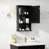 A black bathroom cabinet with its door open, displaying various toiletries and accessories, mounted on a speckled white wall above a sink. Podgląd zdjęcia produktu