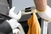 A close-up shot of a person's gloved hand holding a ladder with an orange cloth hanging from it. Voir les images du produit
