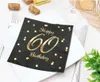 A table setting with a black napkin featuring gold 'Happy 60th Birthday' text and confetti, placed on a white plate. Anteprima dell’immagine prodotto