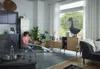 A woman is using a white cordless vacuum cleaner to clean a living room floor. Anteprima dell’immagine prodotto