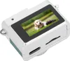 A small, silver digital camera with a screen displaying a puppy. Náhľad obrázku produktu