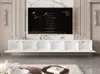 A modern living room with a wall-mounted TV and entertainment unit. Voir les images du produit