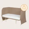 A beige baby bed with a white mattress is shown against a light gray background. Náhľad obrázku produktu