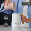 A person is pouring milk from a pitcher into a white electric milk frother. Produktbild-Vorschau